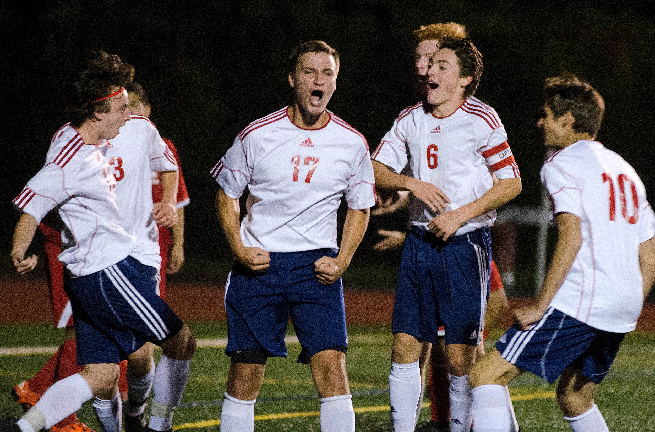 Cade McHugh (left) celebrates with Andrew Maiato (middle), John Cavanagh  and Chris Renault after he scored a header late in the game to give the Patriots a 1-0 lead.