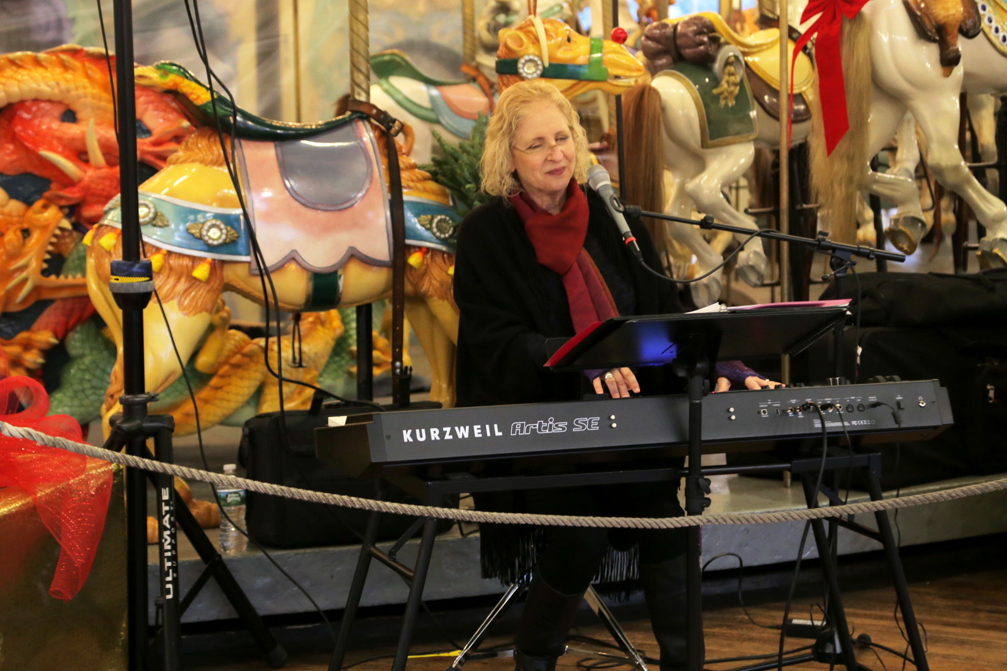 Debra Mann plays Christmas Carols on the piano for those waiting