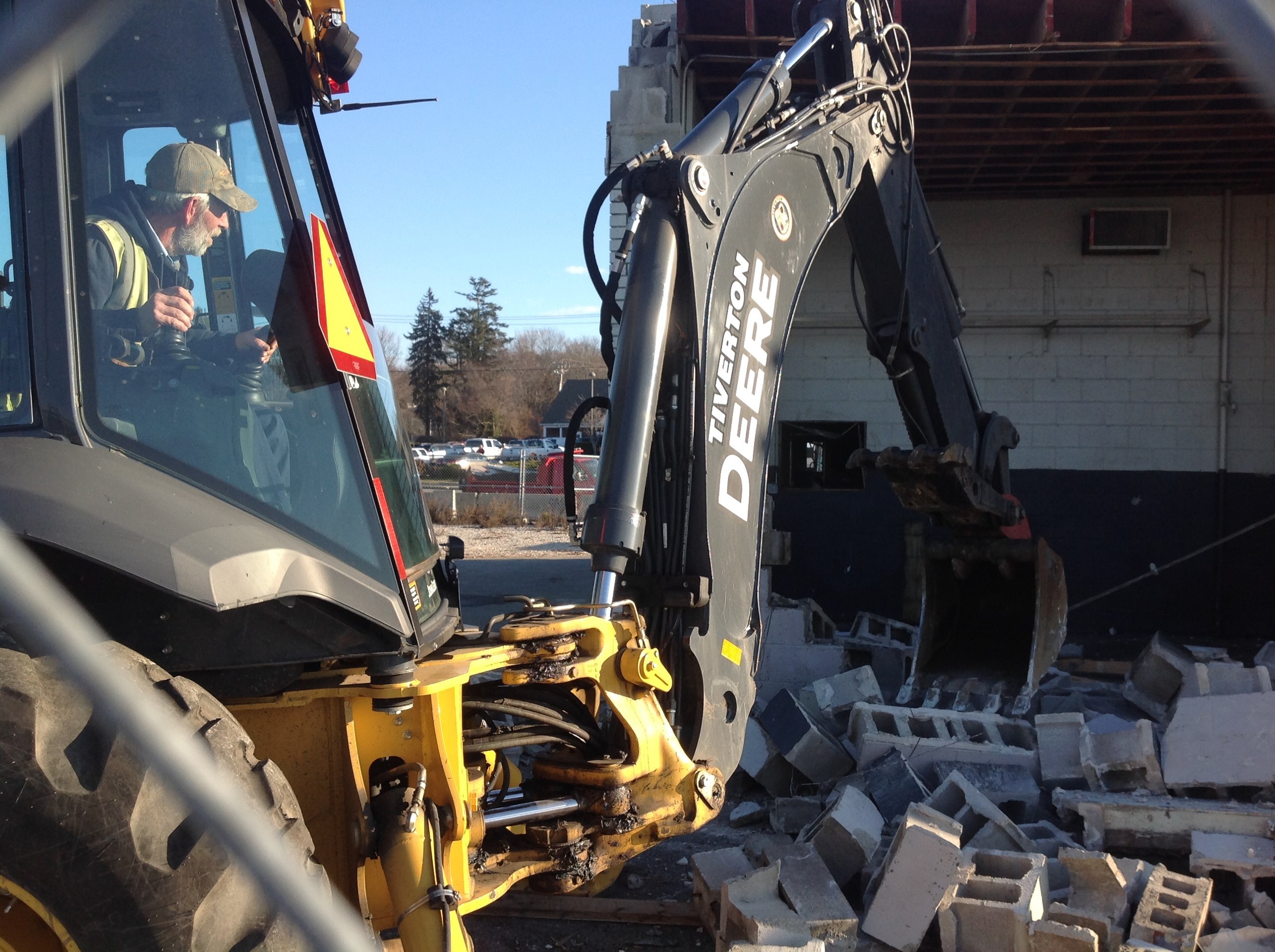 Tiverton Public Works equipment operator Roger St. Ours pulls down a section of the station's west wall.
