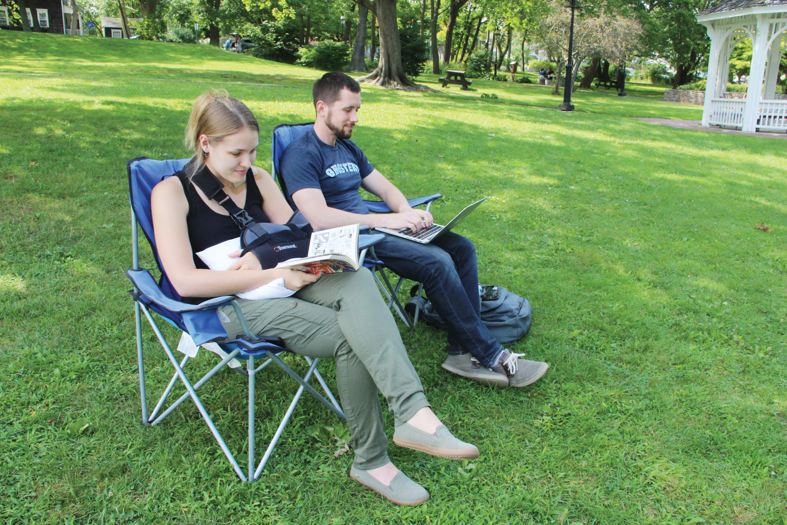 TWO FORMS OF PRINT: Amy Elsberger and Dave Counts found Pawtuxet Park as a good spot to do some book and computer screen reading Sunday.
