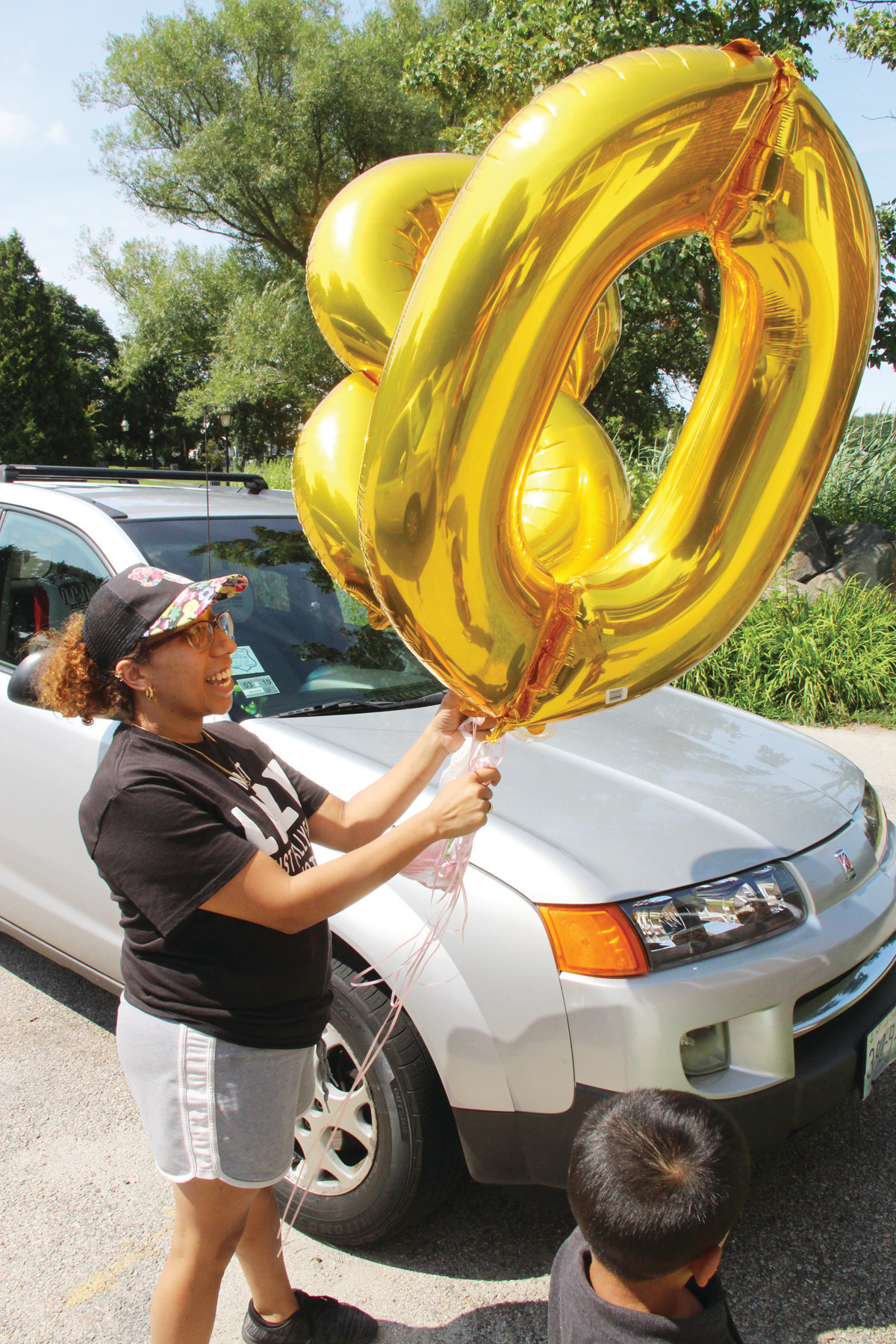 THE BIG 80: Massiel Garcia brings in balloons for the surprise 80th birthday party for Nereida Serrano held Sunday at the Aspray Boathouse in Pawtuxet.