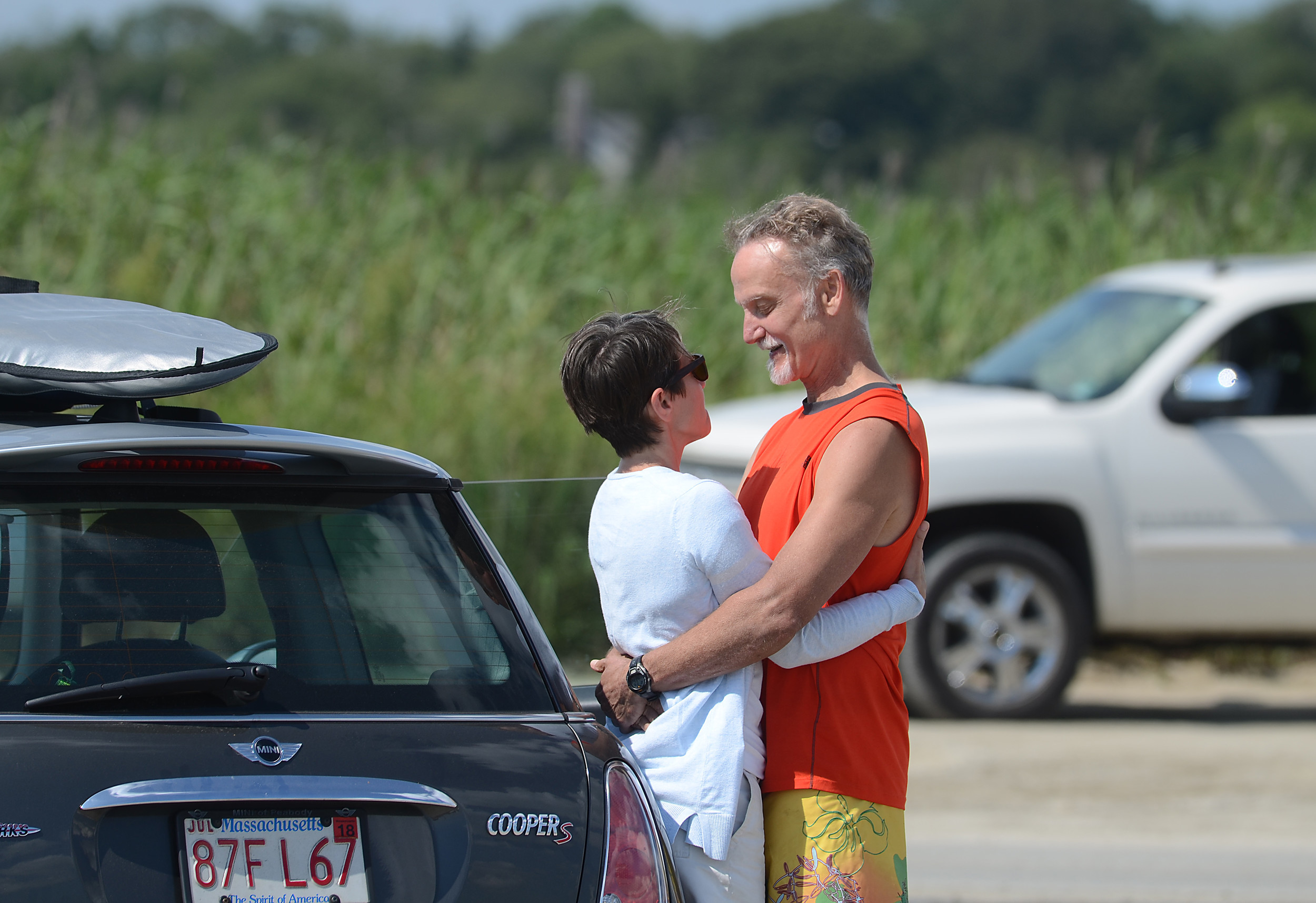 A couple enjoys the afternoon as cars line up to leave the beach.