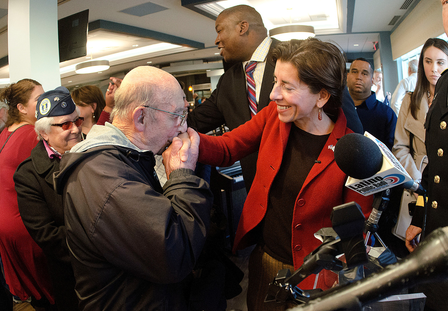 WWII veteran Aime SanSouci kisses the hand of Governor Gina Raimondo as veterans lined up to meet her after the ceremony. The 88th Infantry Division veteran was injured during the war in France and is thankful to be in the new veterans home.