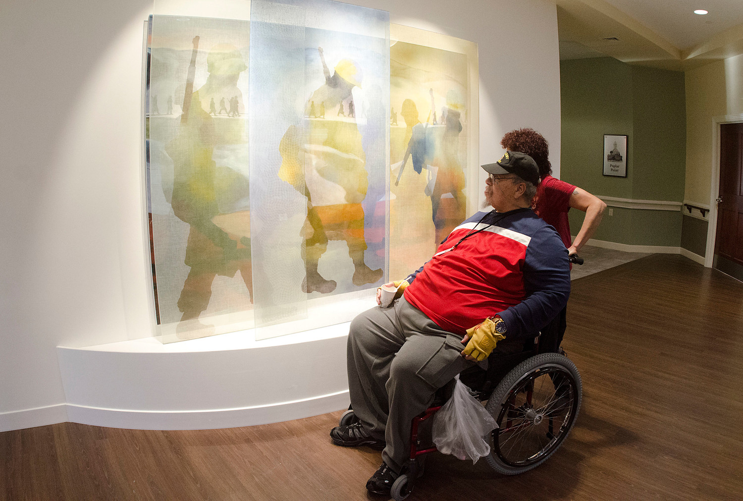 Vietnam era veteran John Leonard and his daughter, Heidi take in a painting by Deborah Baronas.