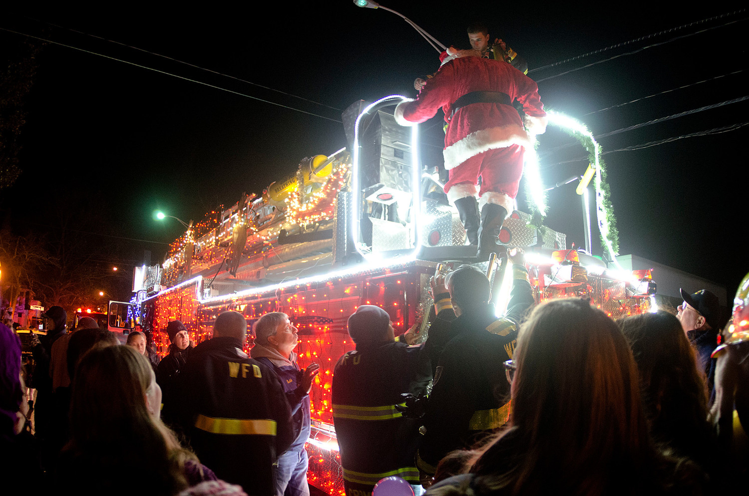 Santa gets down from atop the Warren Fire Department fire engine on Main St. in front of town hall.