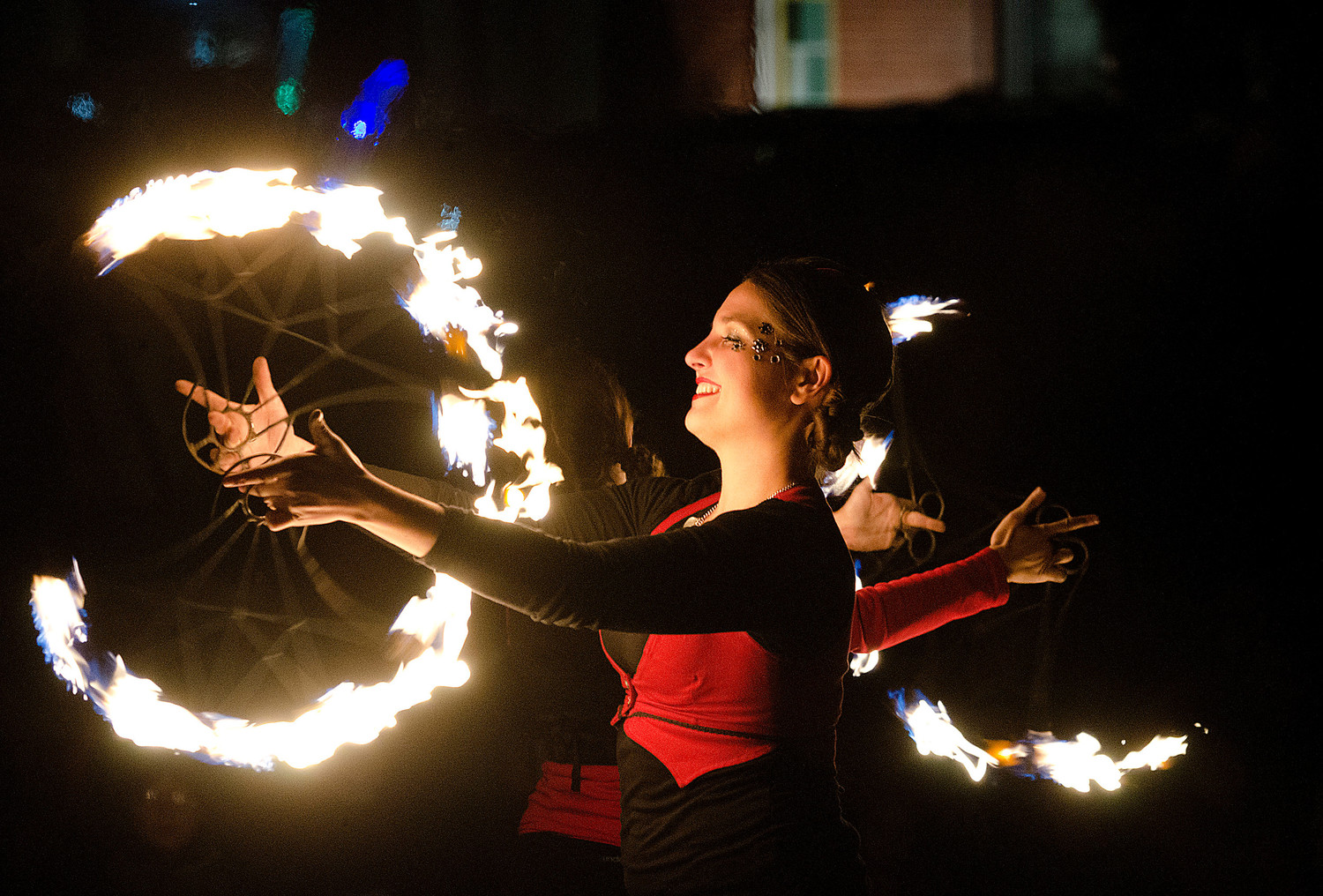 Casey Acacia of Circus Dynamics spins fire during their show on Narragansett Way.