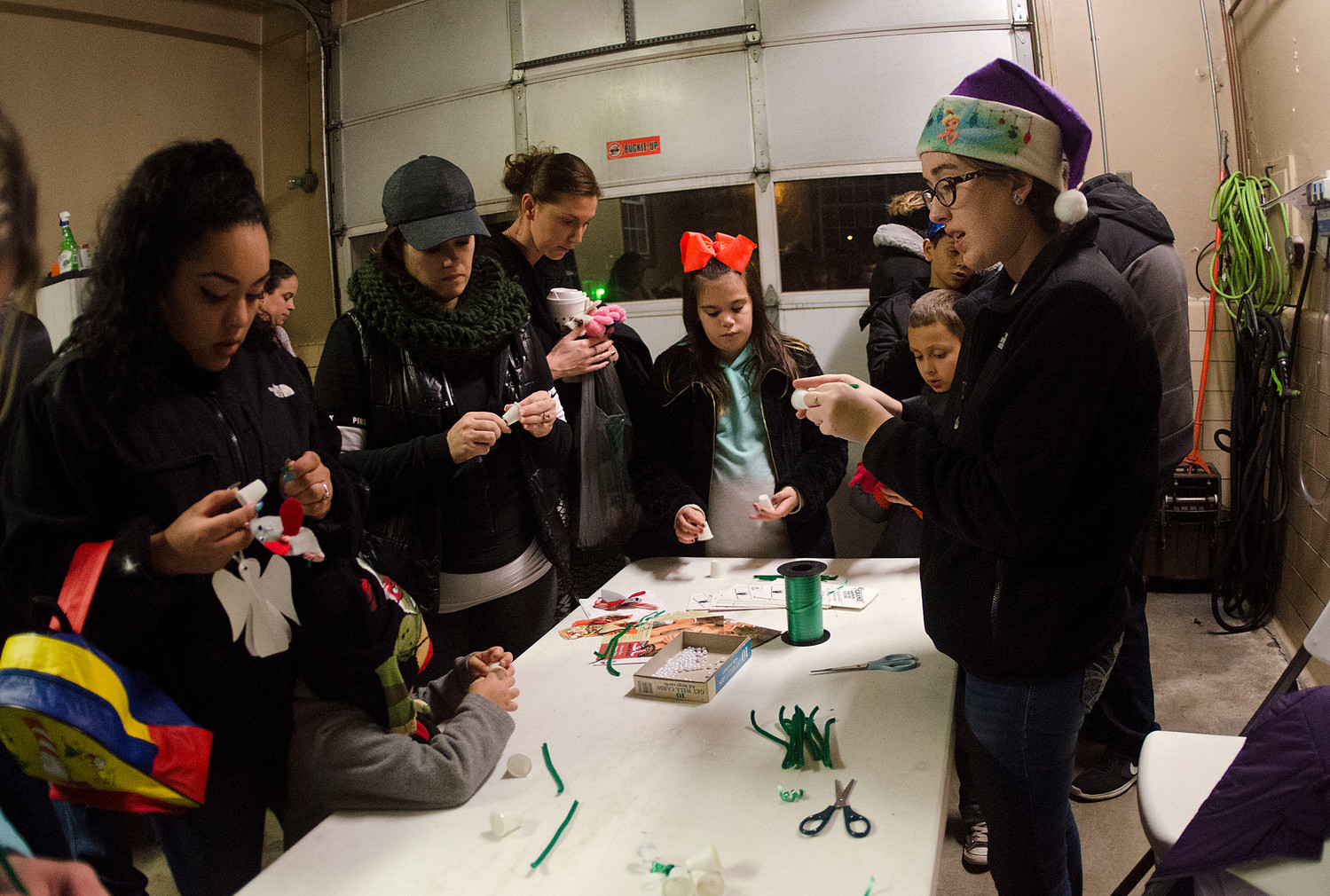 Grange member Lauren Kenyon (left) makes ornaments with the crowd at the Miller St. Rescue Station.