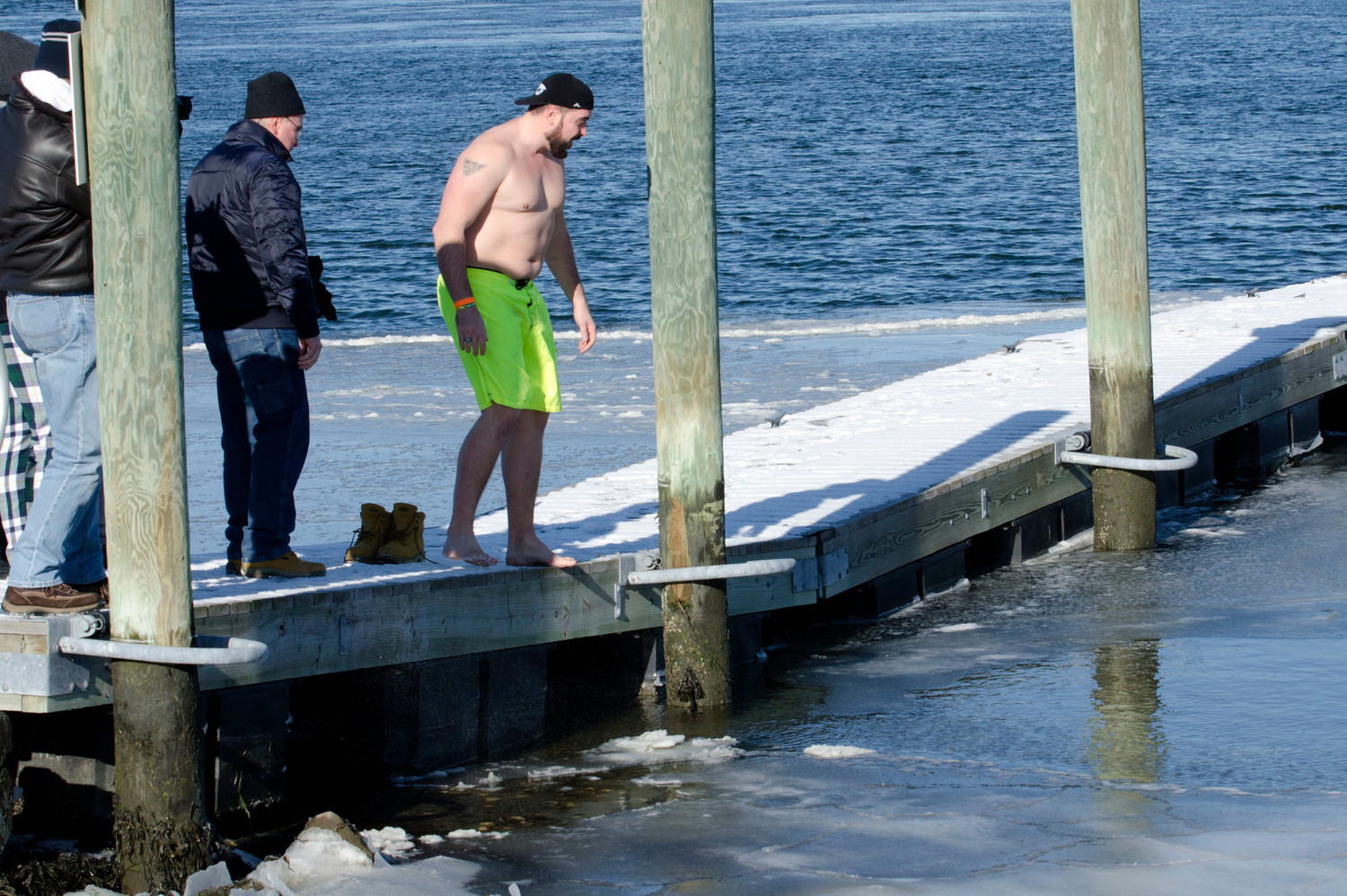 Westport resident Mark Arseneault looks for an opening in the ice so he could make his New Year's Day plunge.