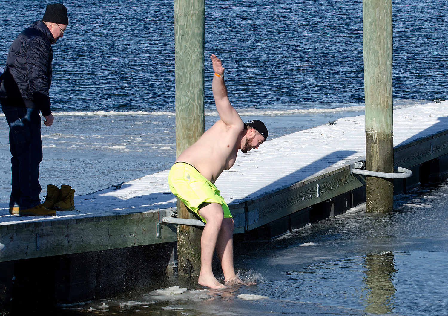 Westport resident Mark Arseneault jumps into the ice covered water at the state boat ramp next to the Back Eddy.
