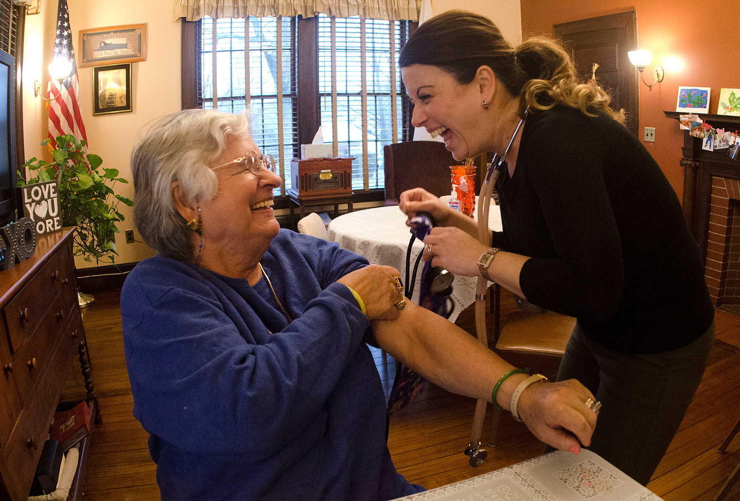 Maria Rodrigues (left) shares a laugh with registered nurse Paula Lage of Willows at Grace Barker during a blood pressure screening before lunch at the Benjamin Church Senior Center.