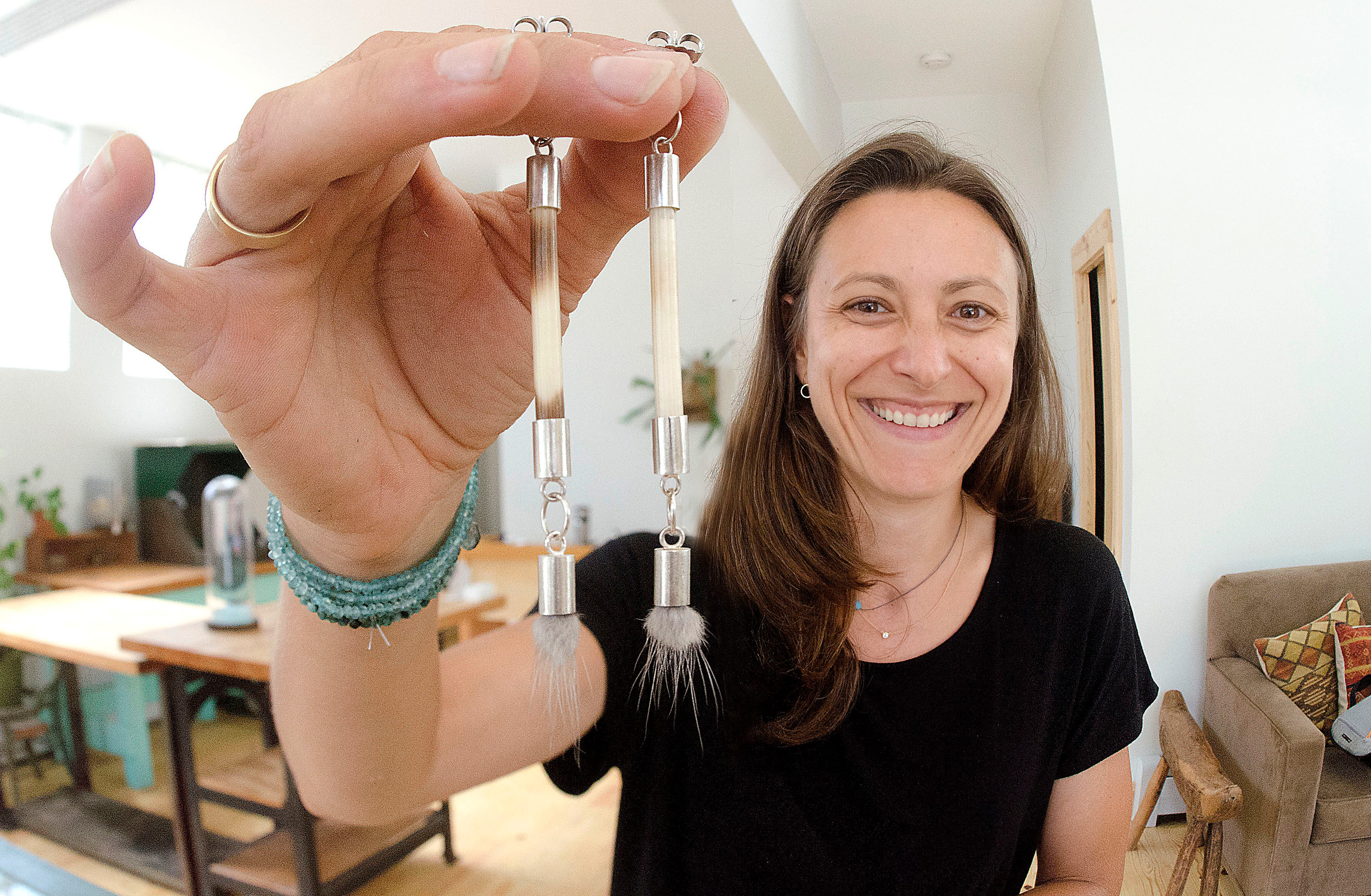 Artist and jeweler Kendall Reiss shows off a pair of earrings she crafted from porcupine quills and mink fur.